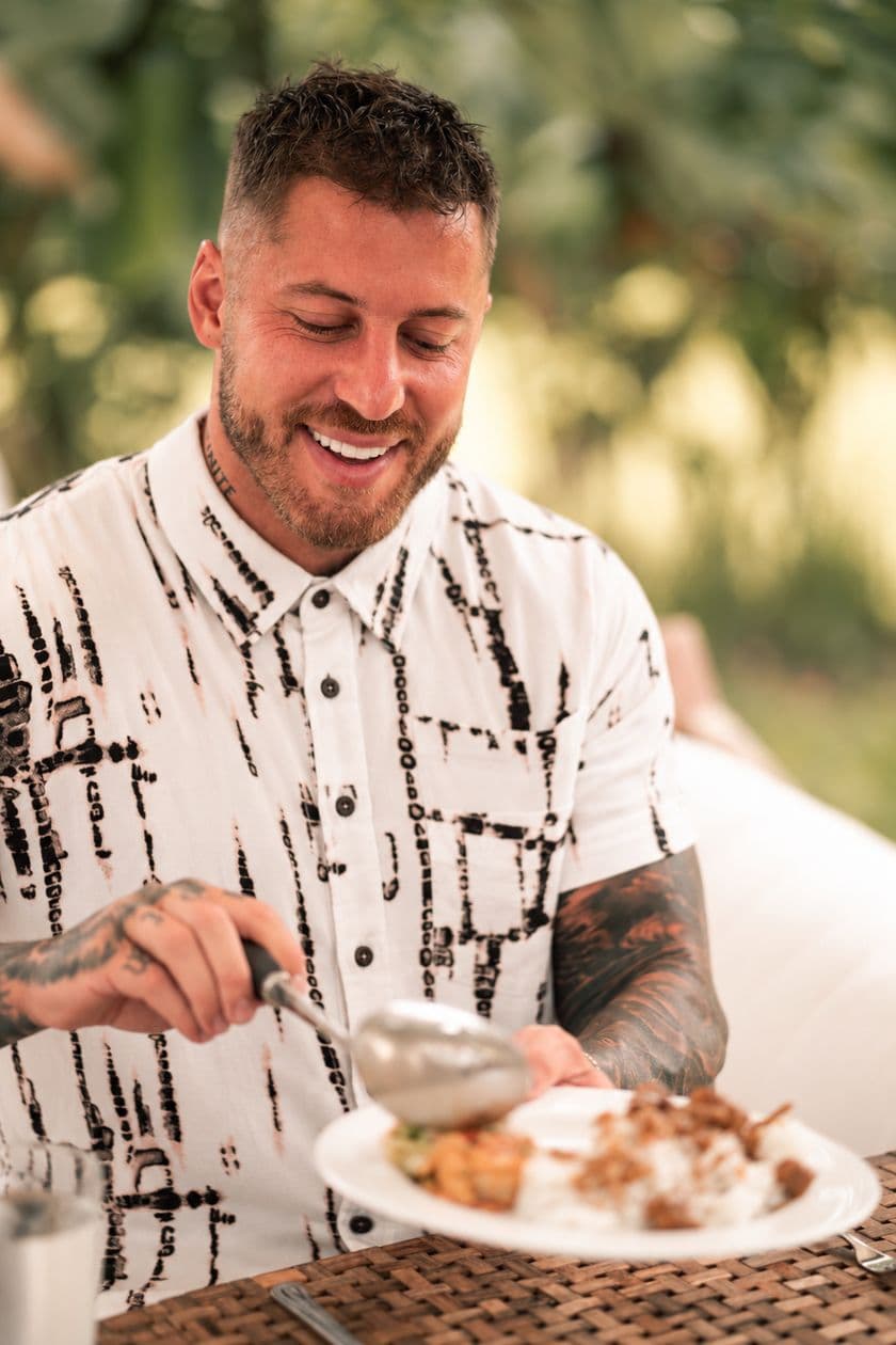 Connor smiling over a plate of Balinese food