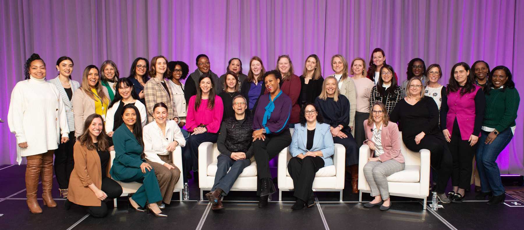 About forty smiling members of AbbVie's Women Leaders of AbbVie employee group posed together on a stage