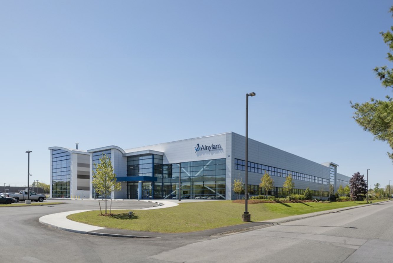 Alnylam's Norton, Massachusetts manufacturing site with the Alnylam name on its glass facade