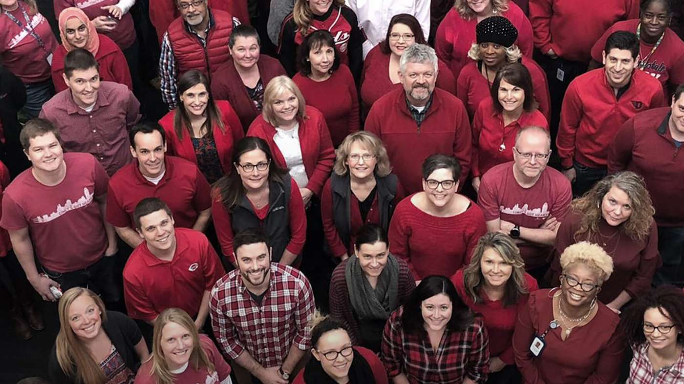 A large group of AtriCure colleagues wearing red gathered together indoors