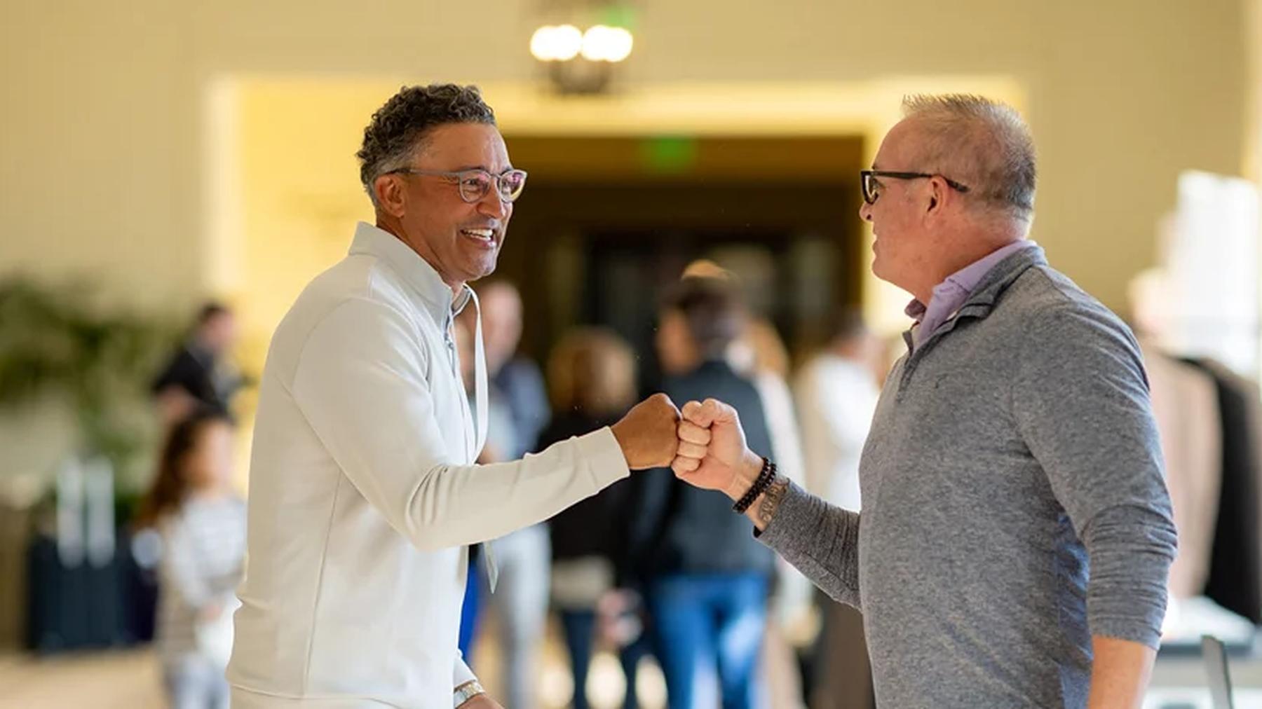 Two BioCryst colleagues smiling and greeting each other at work