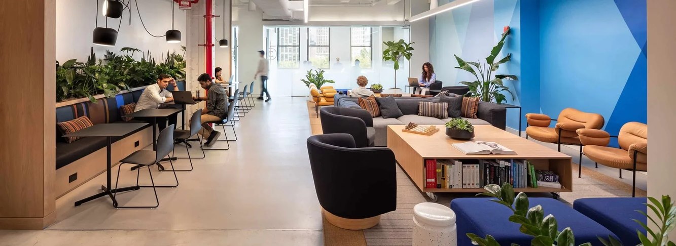 Butterfly Network colleagues working in the bright, plant-filled sitting area of its New York office