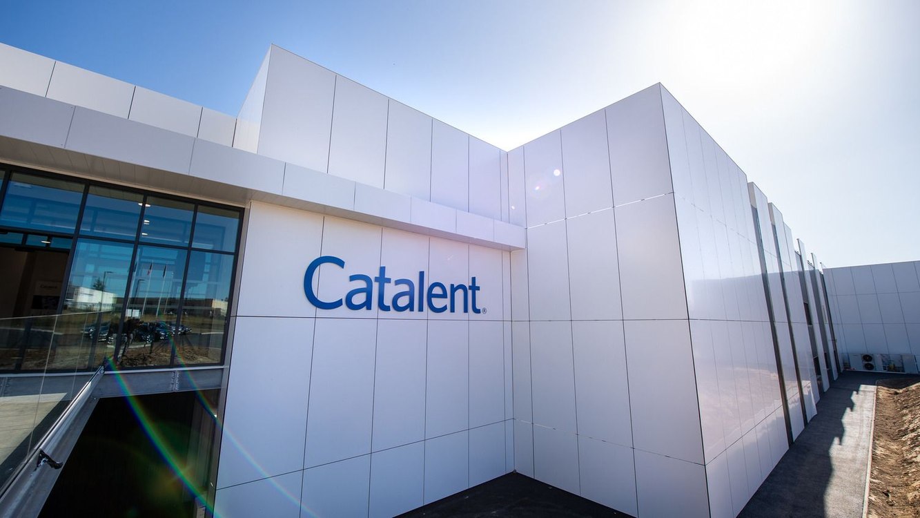 A modern white Catalent facility with the Catalent name on its facade under a bright sky