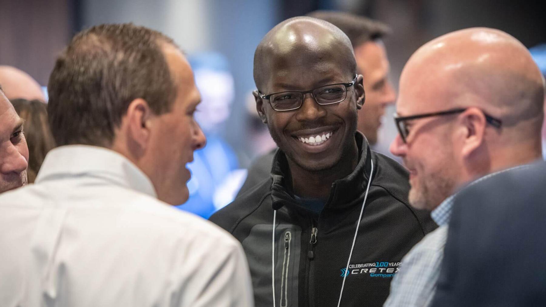 Cretex colleagues laughing together in conversation at the Cretex Medical Conference