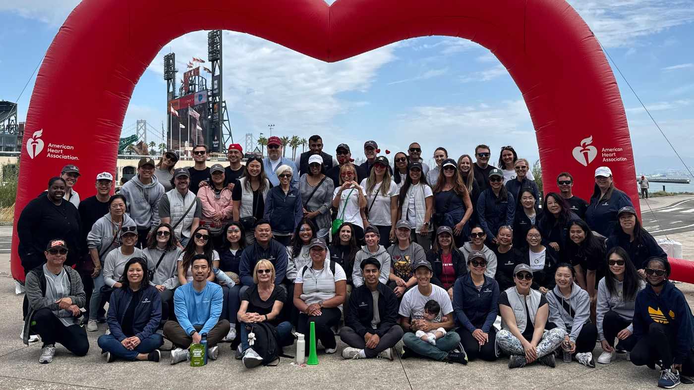 About eighty Cytokinetics employees posed together under a red heart arch at the American Heart Association Heart Walk