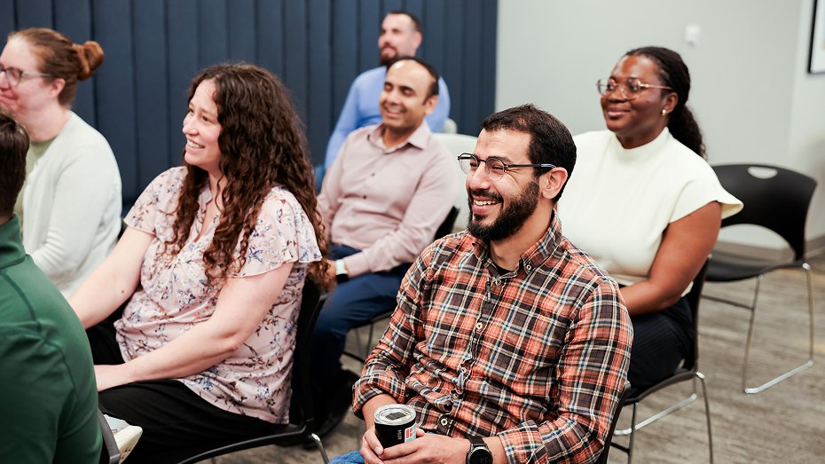 Smiling Deciphera colleagues seated together and laughing at a team gathering