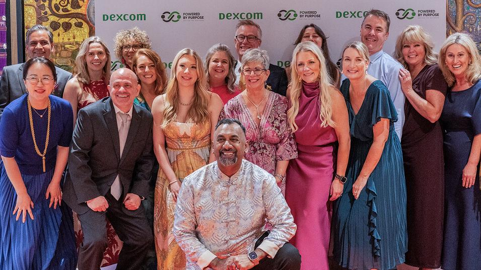 About twenty smiling Dexcom colleagues dressed up together at a Dexcom Powered by Purpose gala