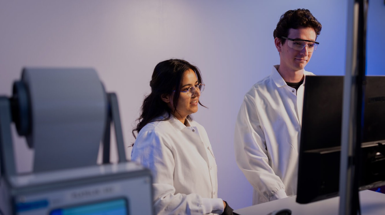 Eikon scientists reviewing work together beside laboratory equipment