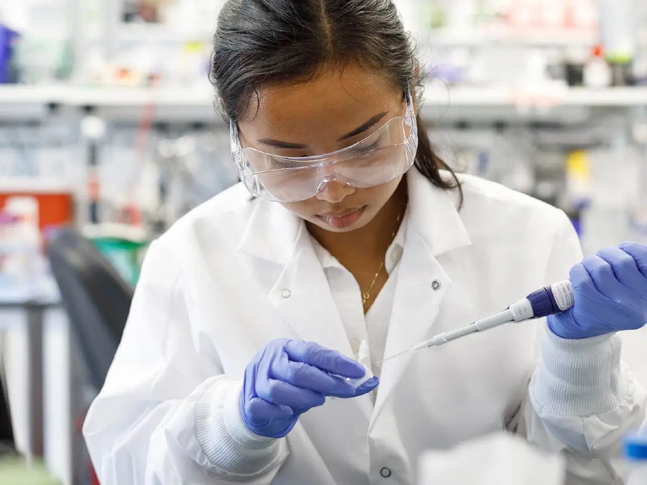 An Entrada scientist pipetting at a laboratory bench