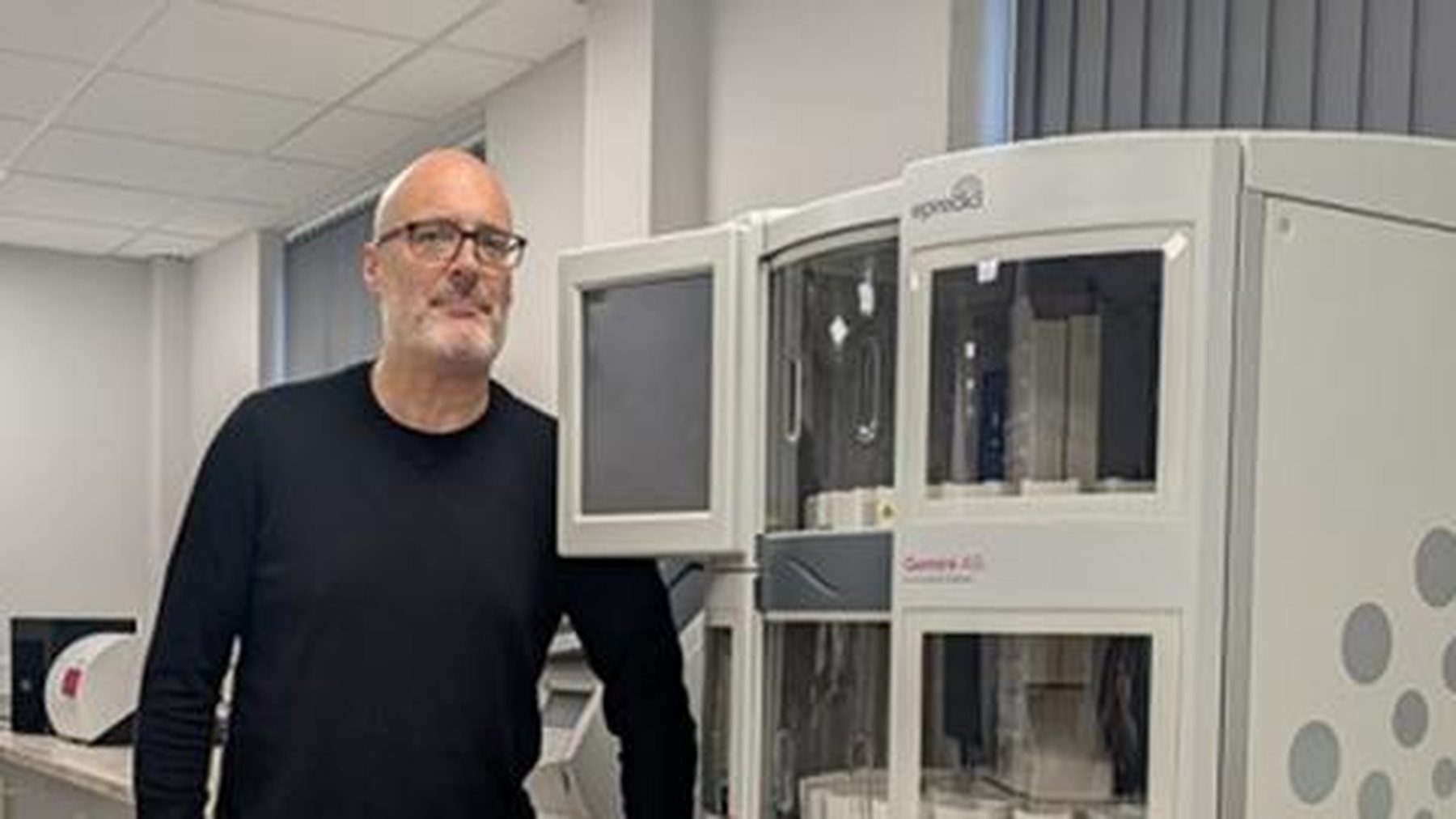 An Epredia employee standing beside laboratory equipment at work