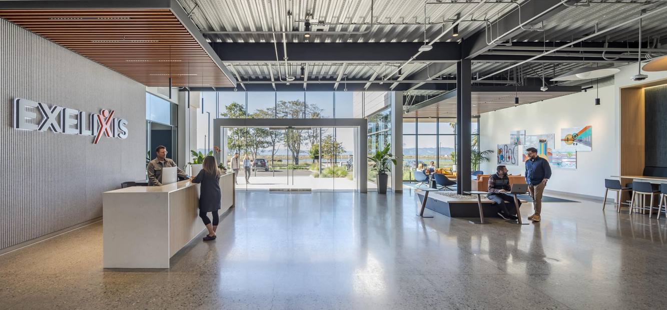 The bright Exelixis lobby with the Exelixis name on the wall and a reception desk