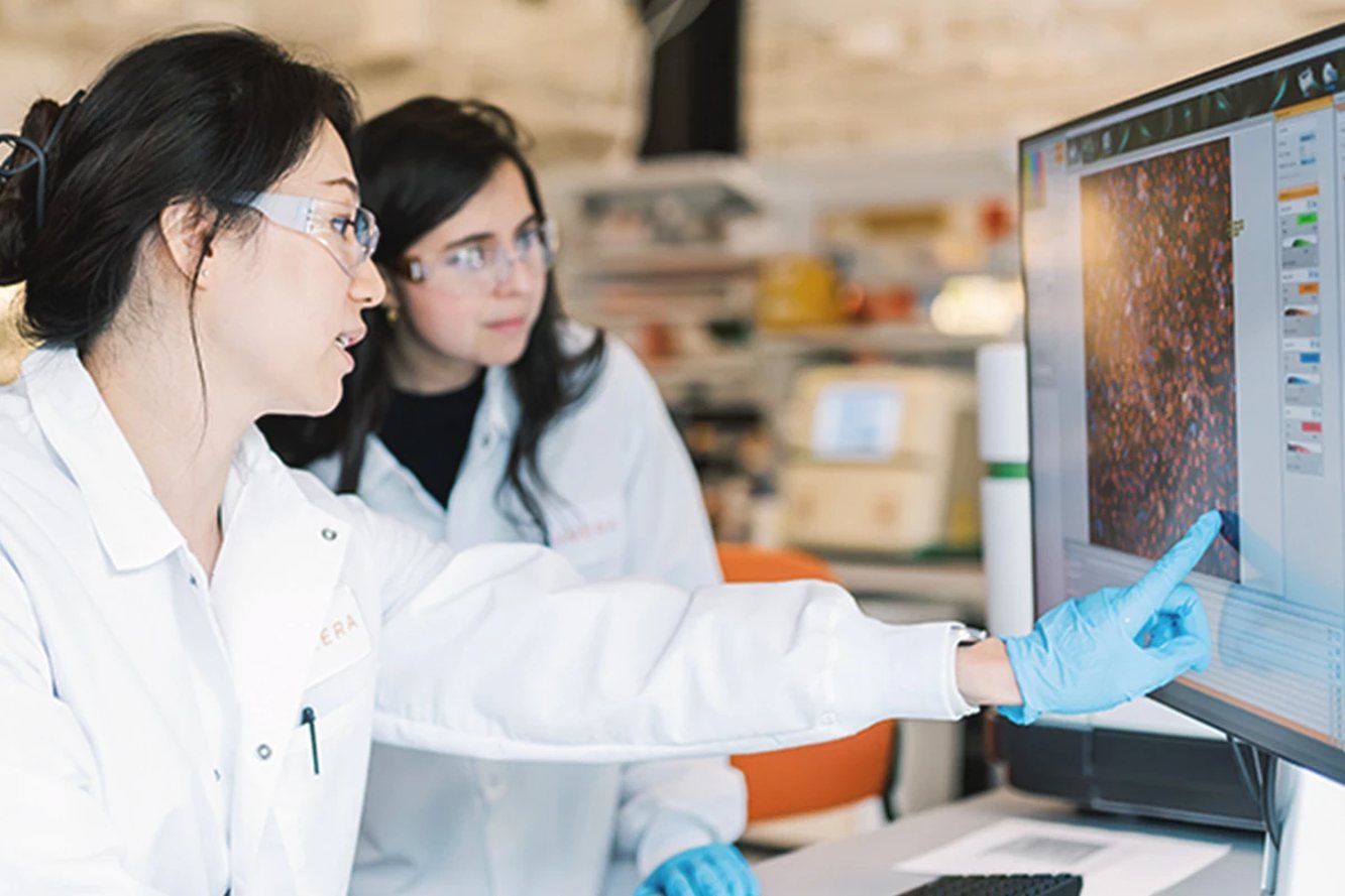 Two Kymera scientists reviewing laboratory results on a computer screen
