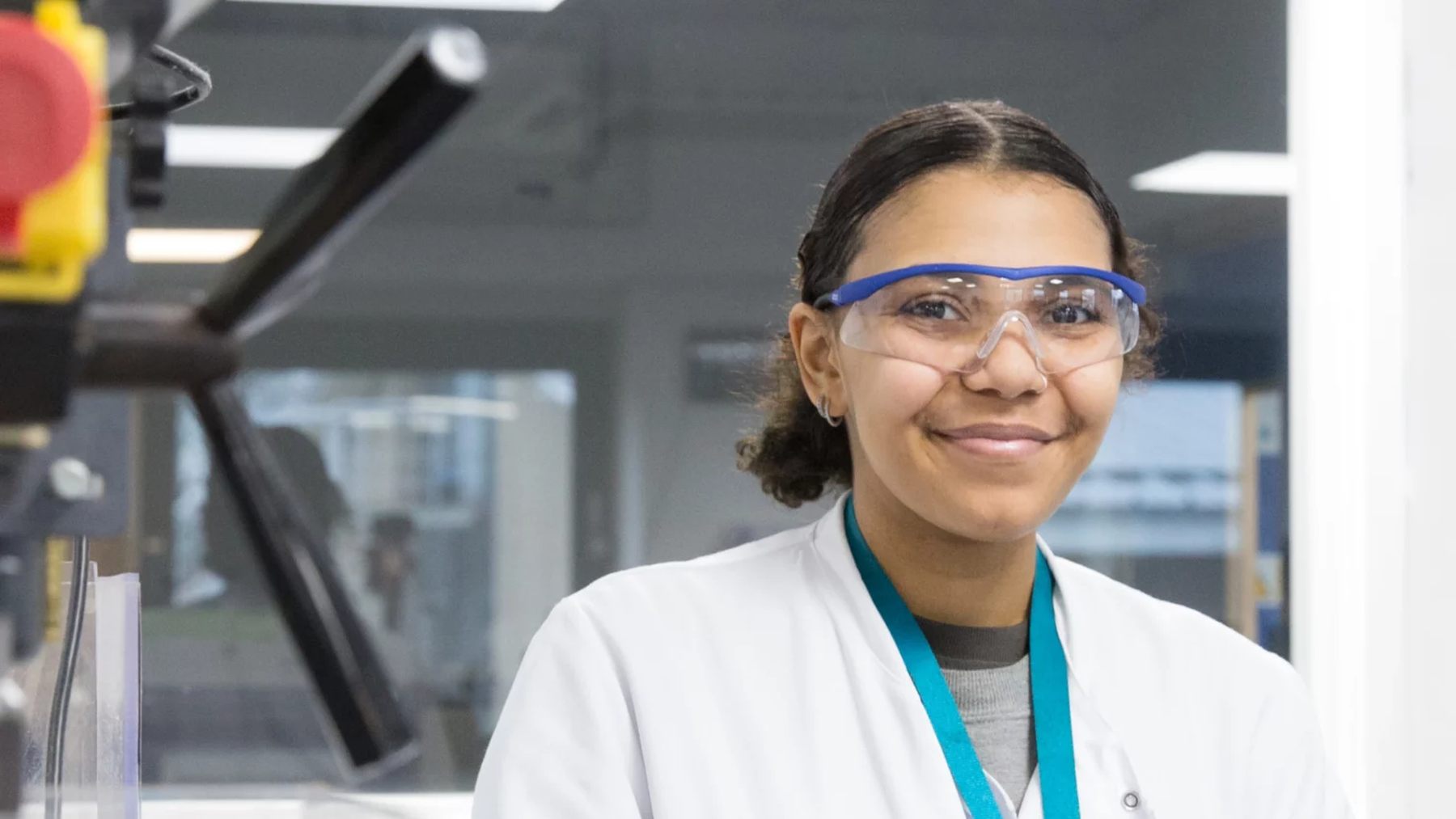 Smiling LGC colleague wearing safety glasses in the laboratory