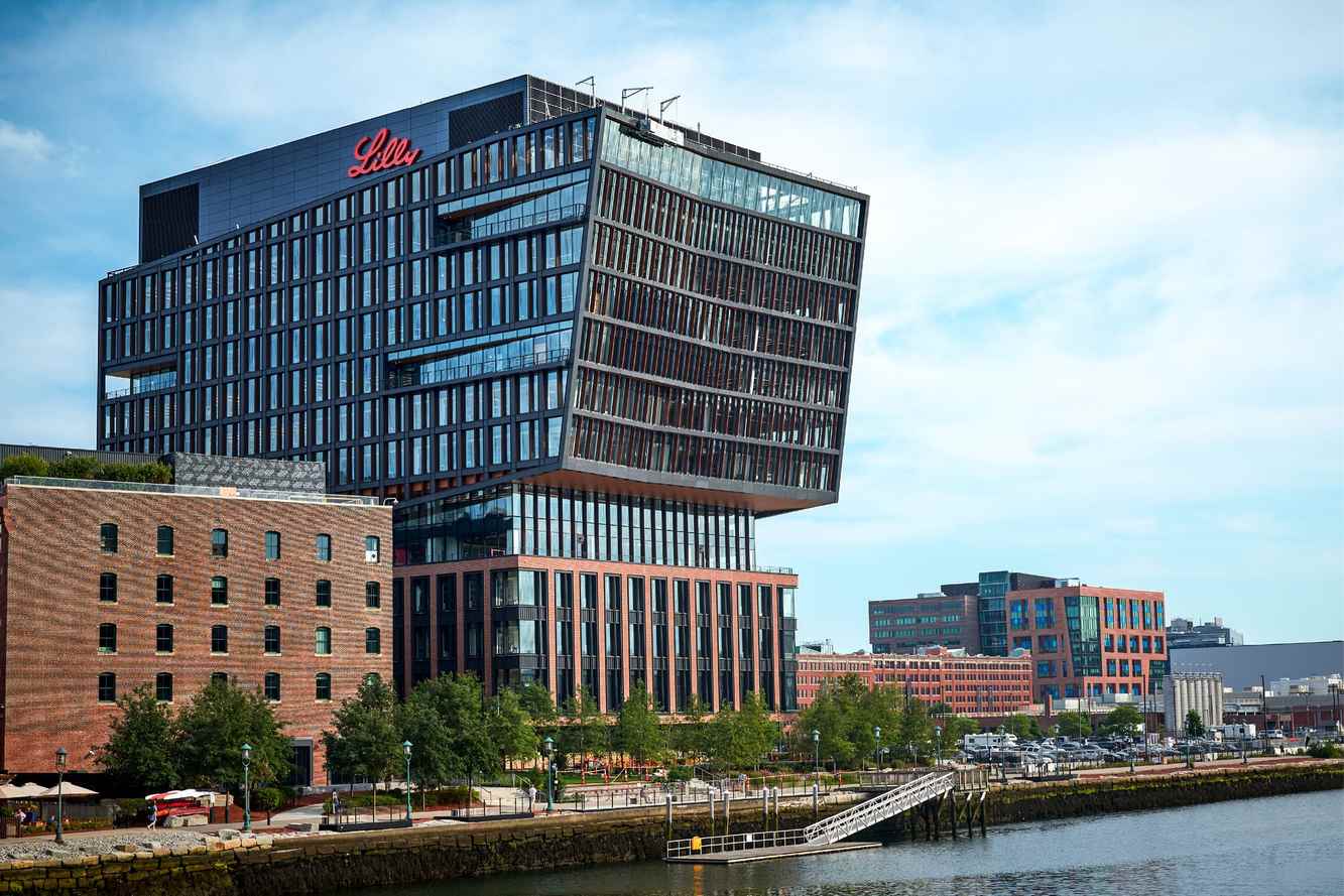 Lilly's Boston Seaport building with the Lilly name on its roof above the waterfront