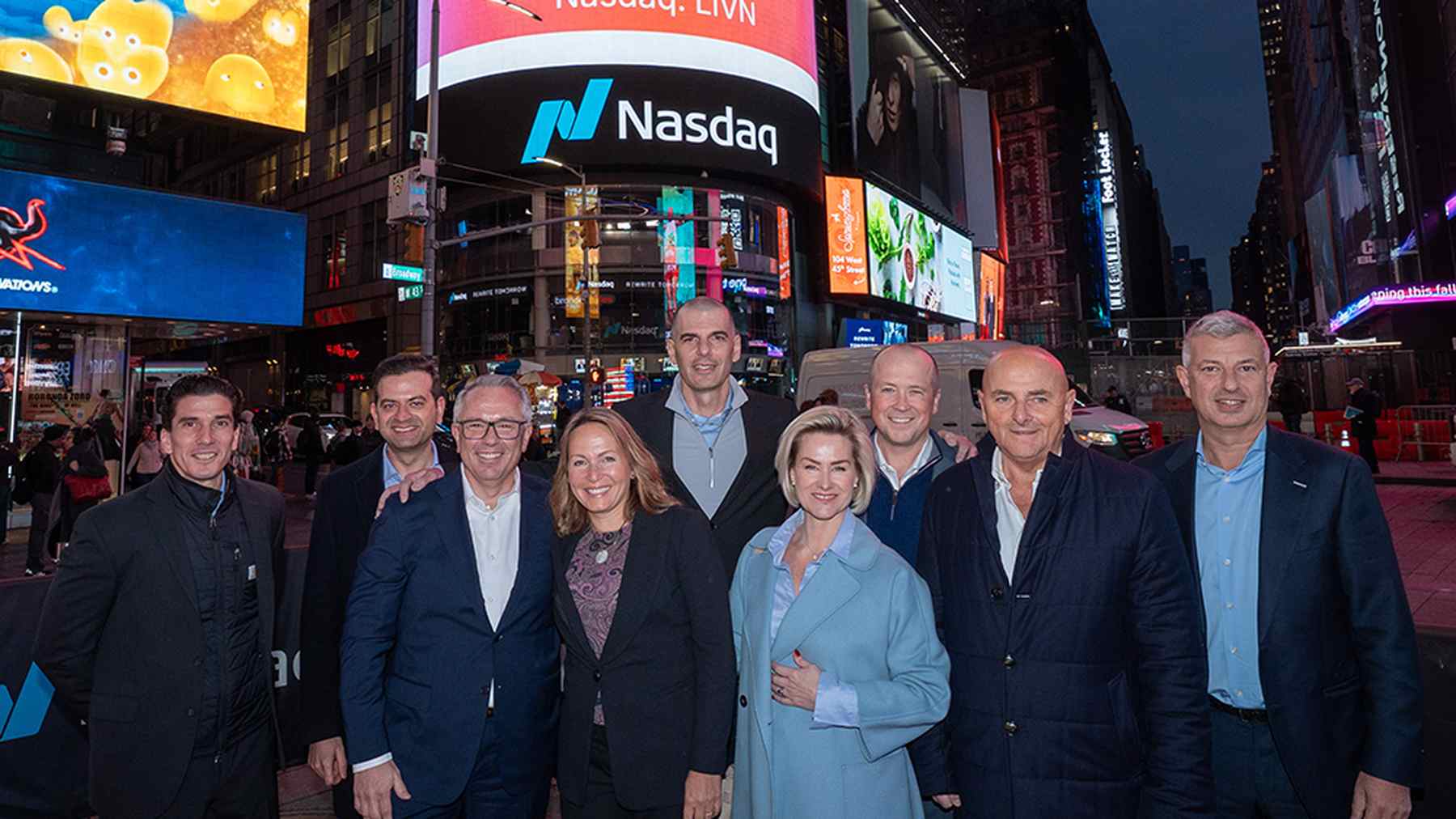 LivaNova colleagues standing together beneath company signage at Nasdaq