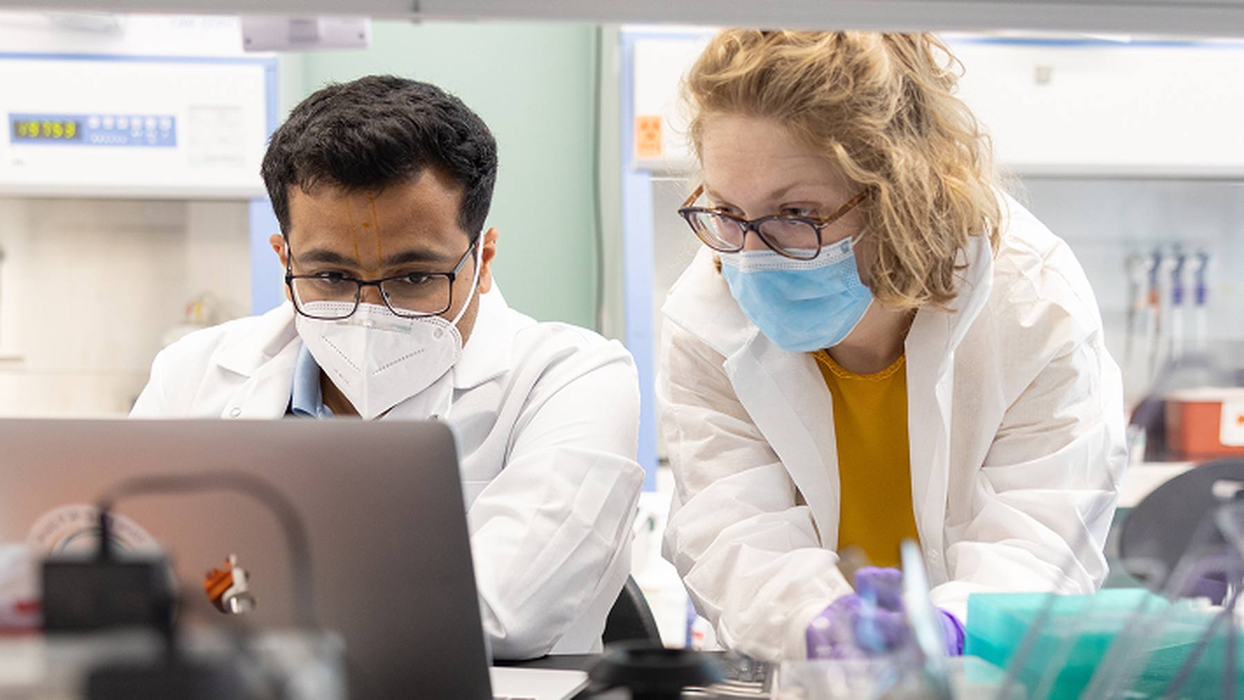 Two Lyell scientists reviewing information together at a laboratory laptop