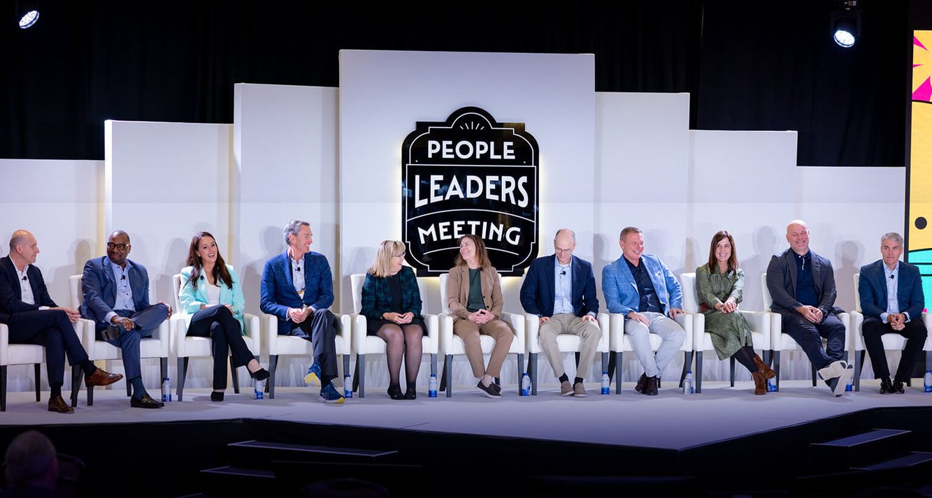 Madrigal's leadership team seated in a row on stage at a People Leaders Meeting