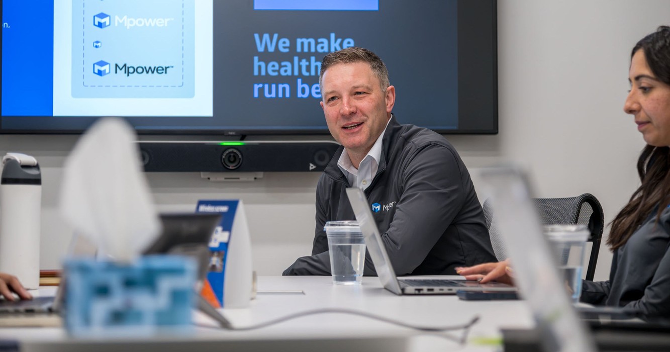Medline colleagues in a meeting room under a screen reading We make healthcare run better
