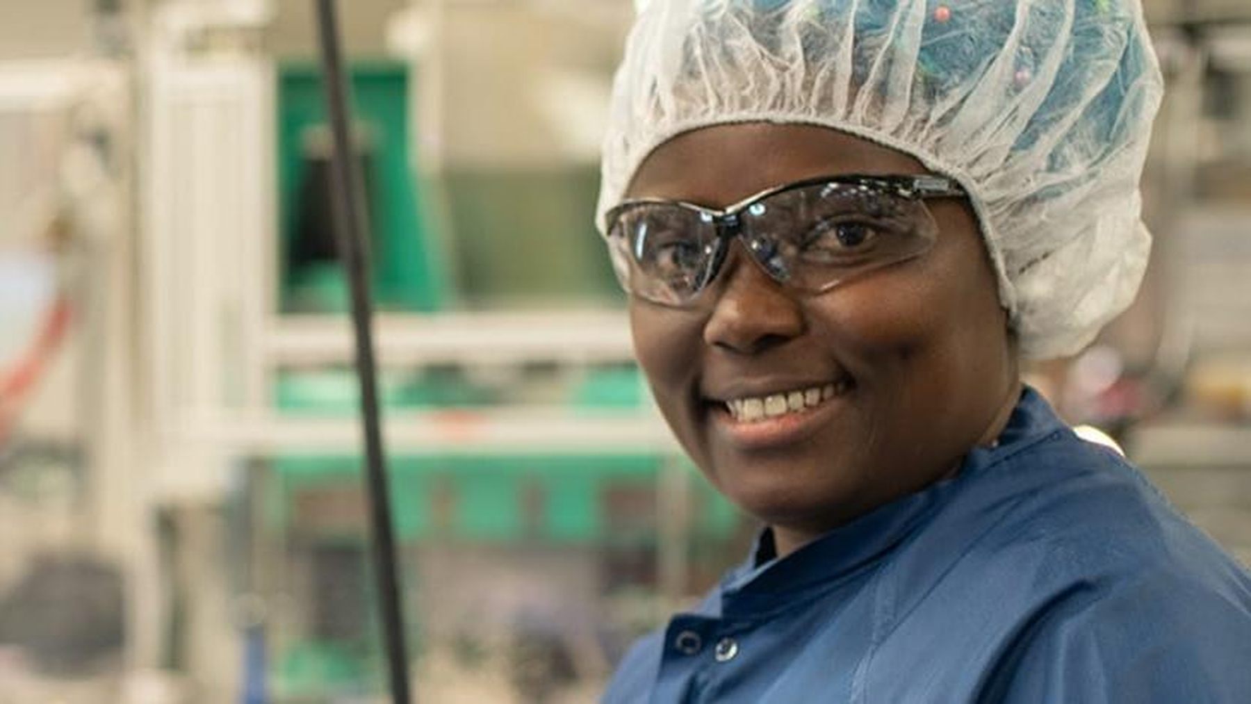 A smiling Merit Medical colleague working in a manufacturing area