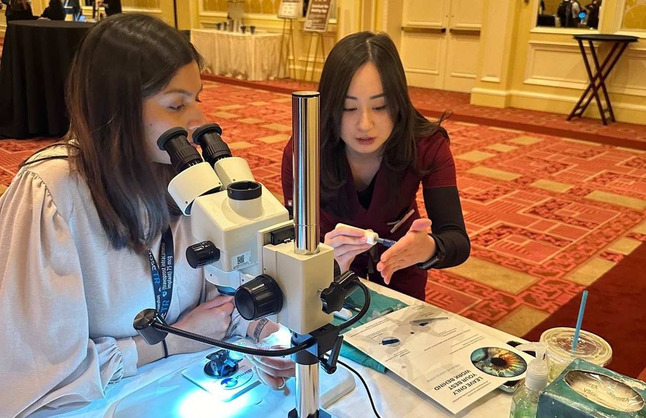 New World Medical colleagues demonstrating ophthalmic techniques with a microscope