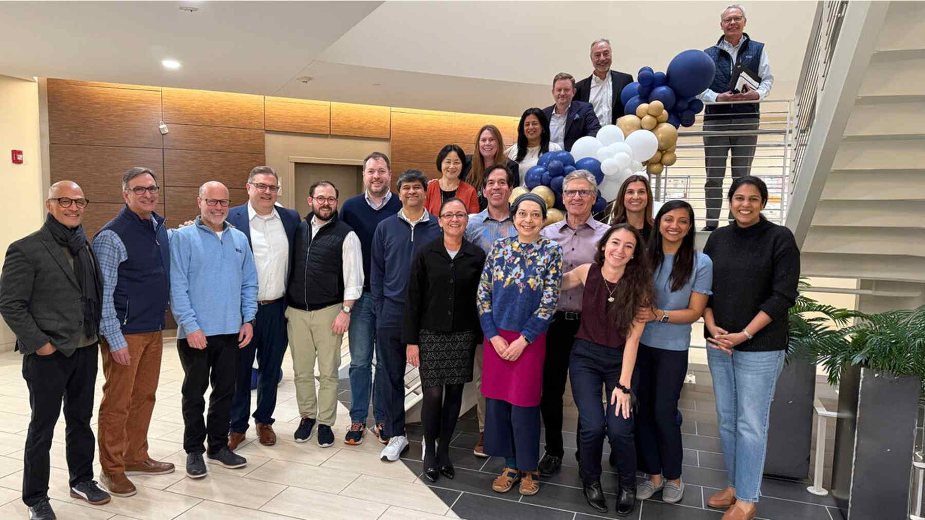 Ocular Therapeutix teammates standing together beside the office staircase