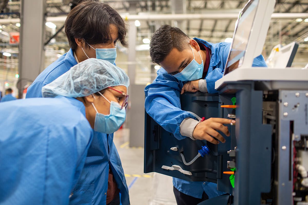 Outset Medical colleagues in gowns and masks working together on a Tablo dialysis system