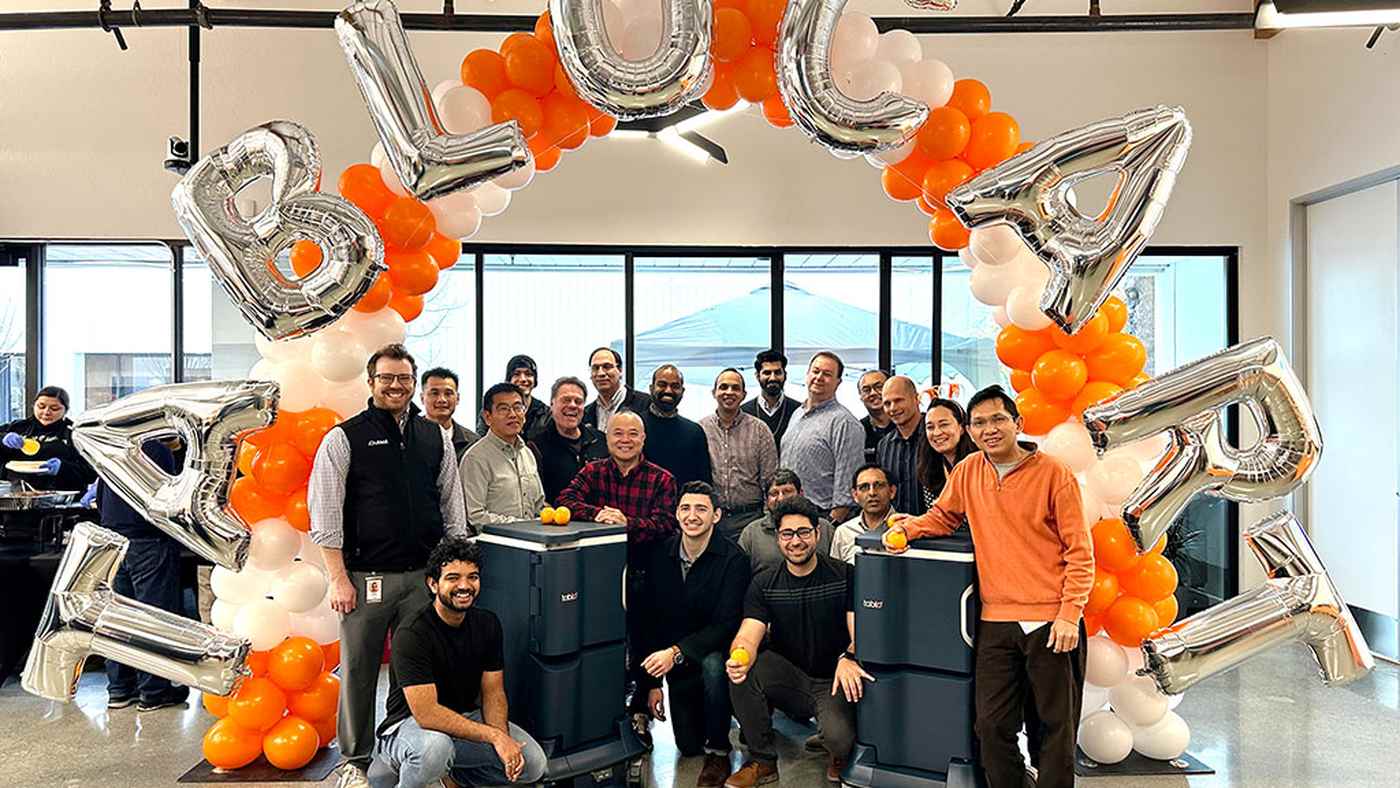 The Outset Medical TabloCart launch team gathered under a silver and orange balloon arch