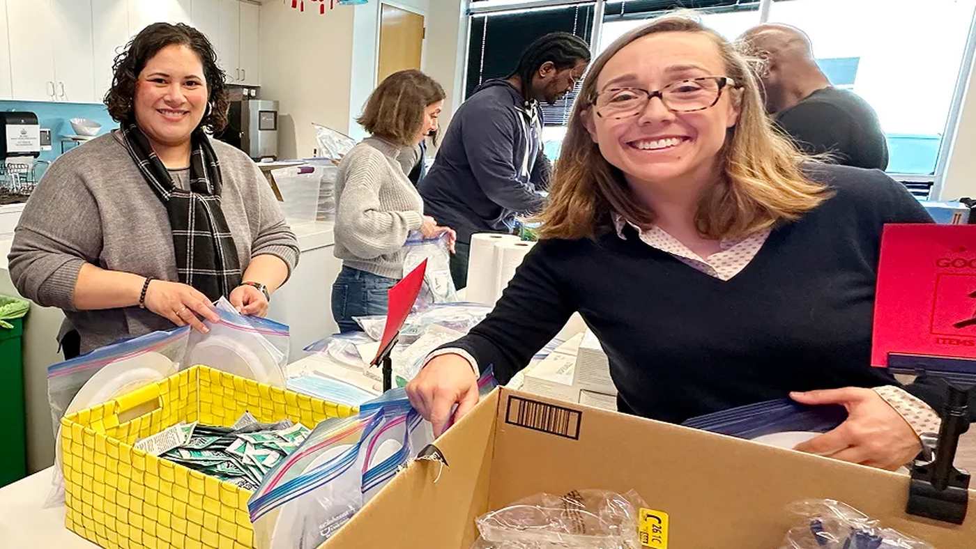Pliant colleagues smiling together while preparing community donations