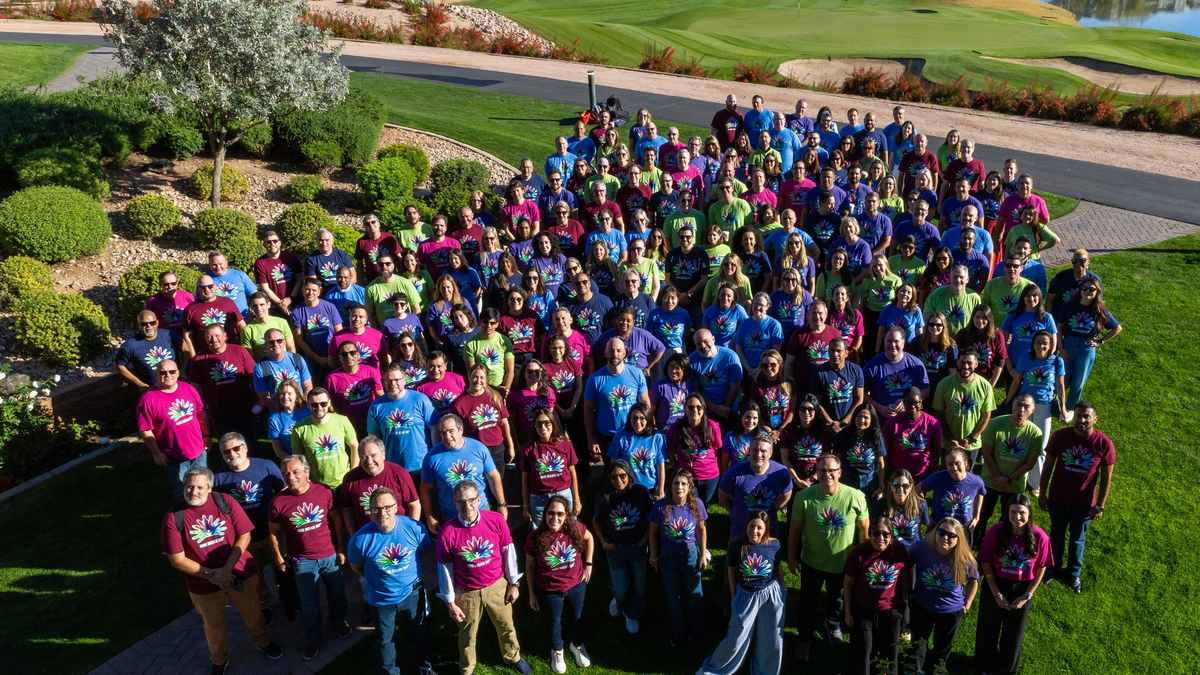 A large PTC Therapeutics team gathered outdoors in colorful shirts