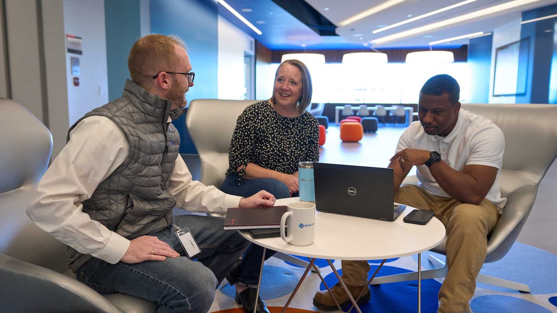 Three REGENXBIO colleagues sharing a discussion around a laptop