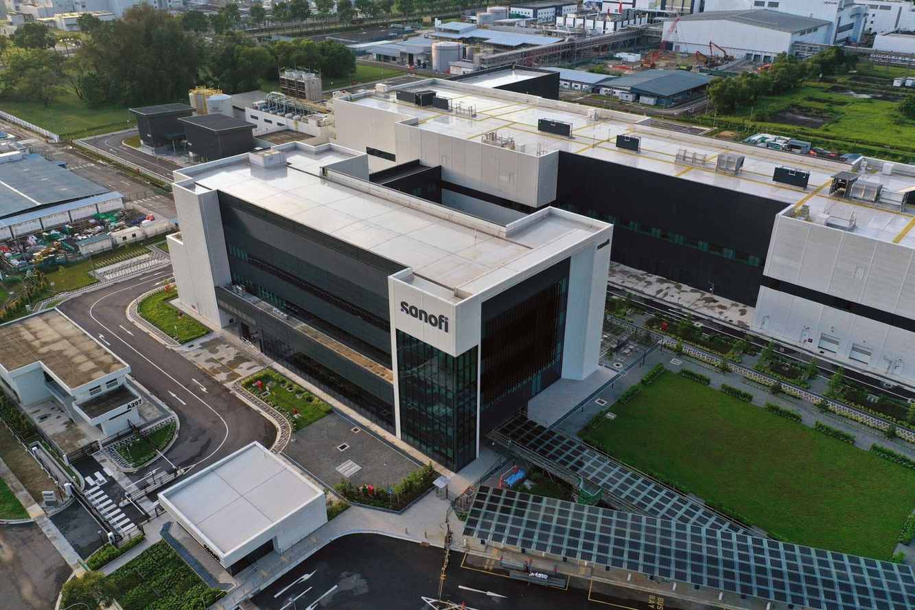 An aerial view of a modern Sanofi manufacturing site with the Sanofi name on its main building
