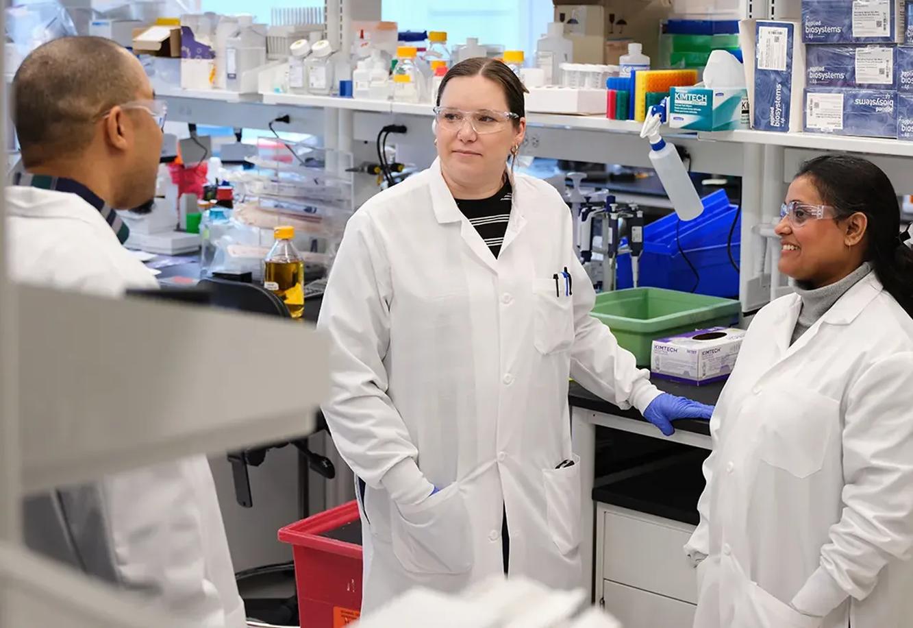 Three Scholar Rock scientists discussing their work in the laboratory