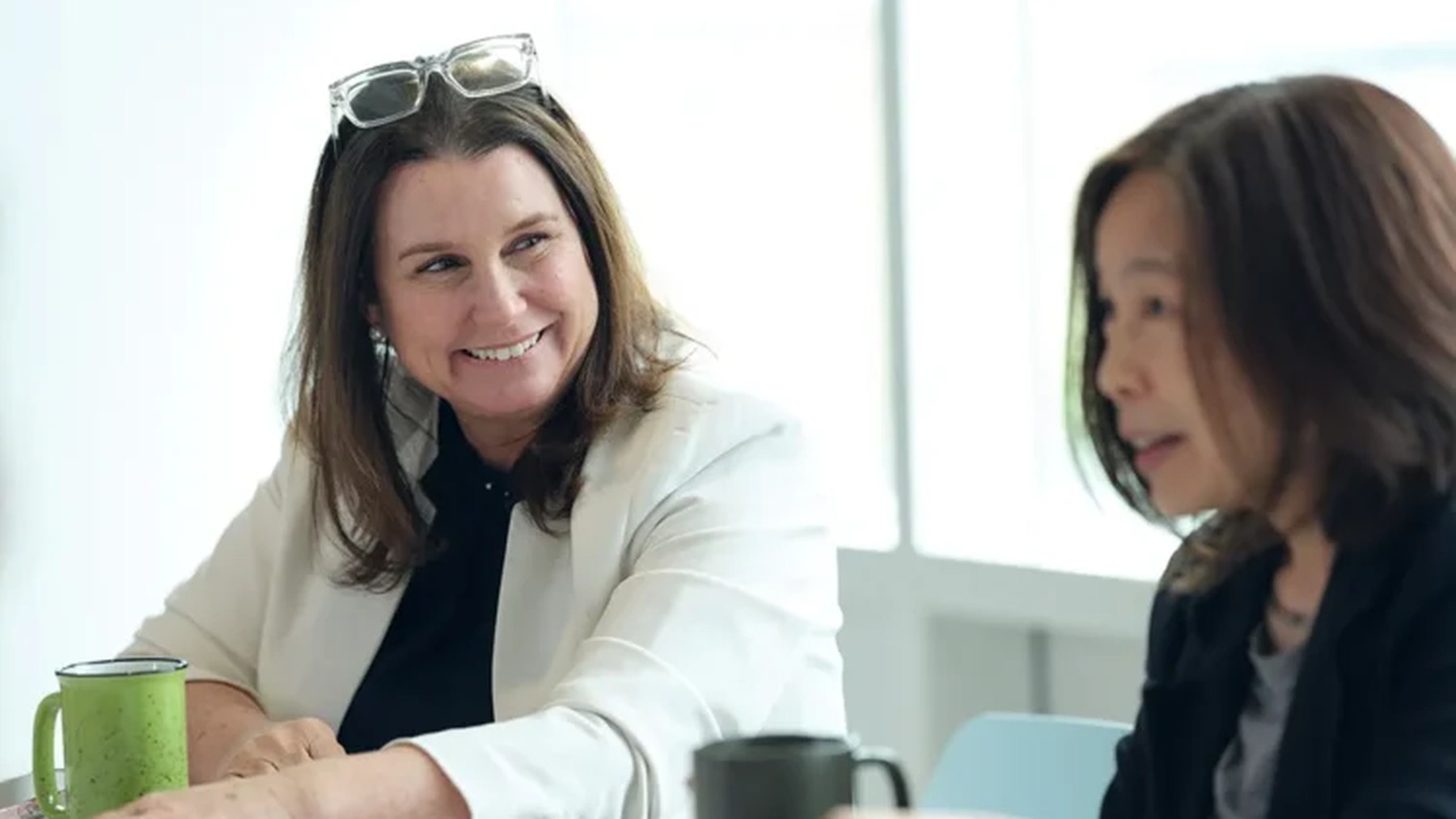 Two Scholar Rock colleagues talking together at a meeting table