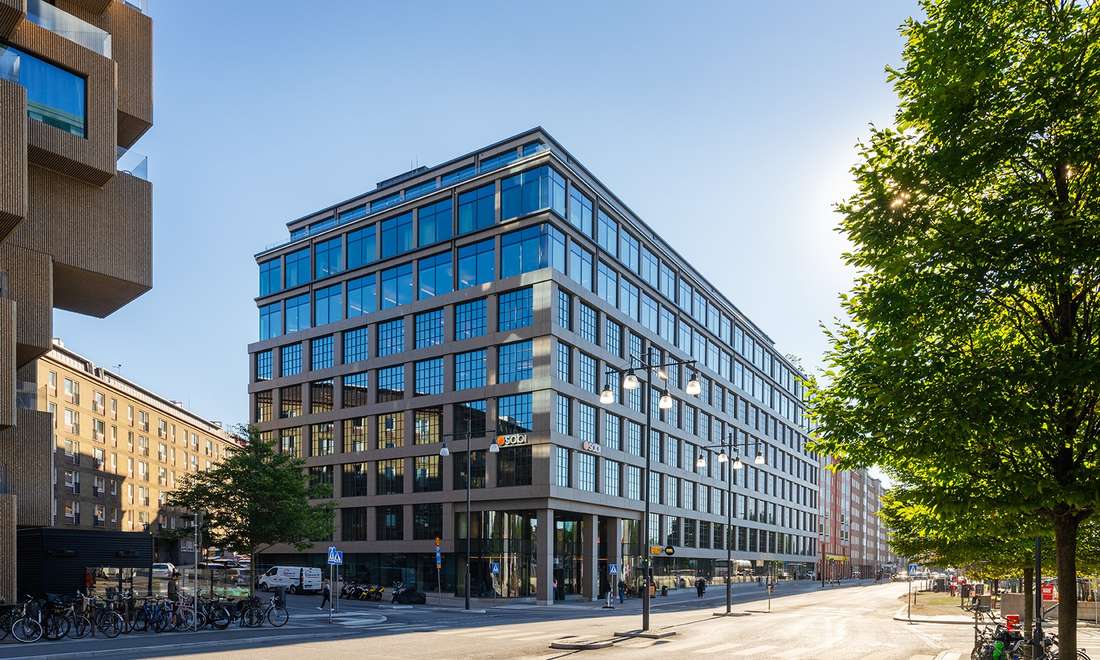 Sobi's glass-fronted head office building on a sunny street in Stockholm