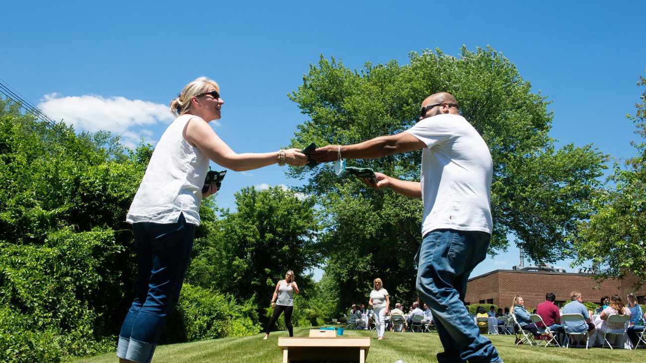 Stoke Therapeutics colleagues playing cornhole at a company outing