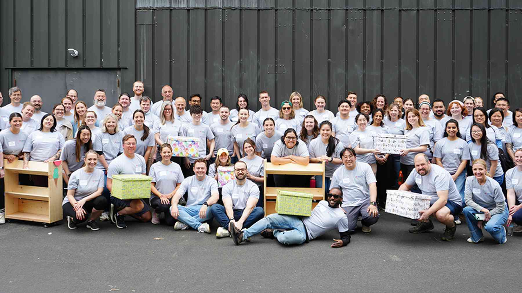 Tango colleagues smiling together with birdhouses made during a team project