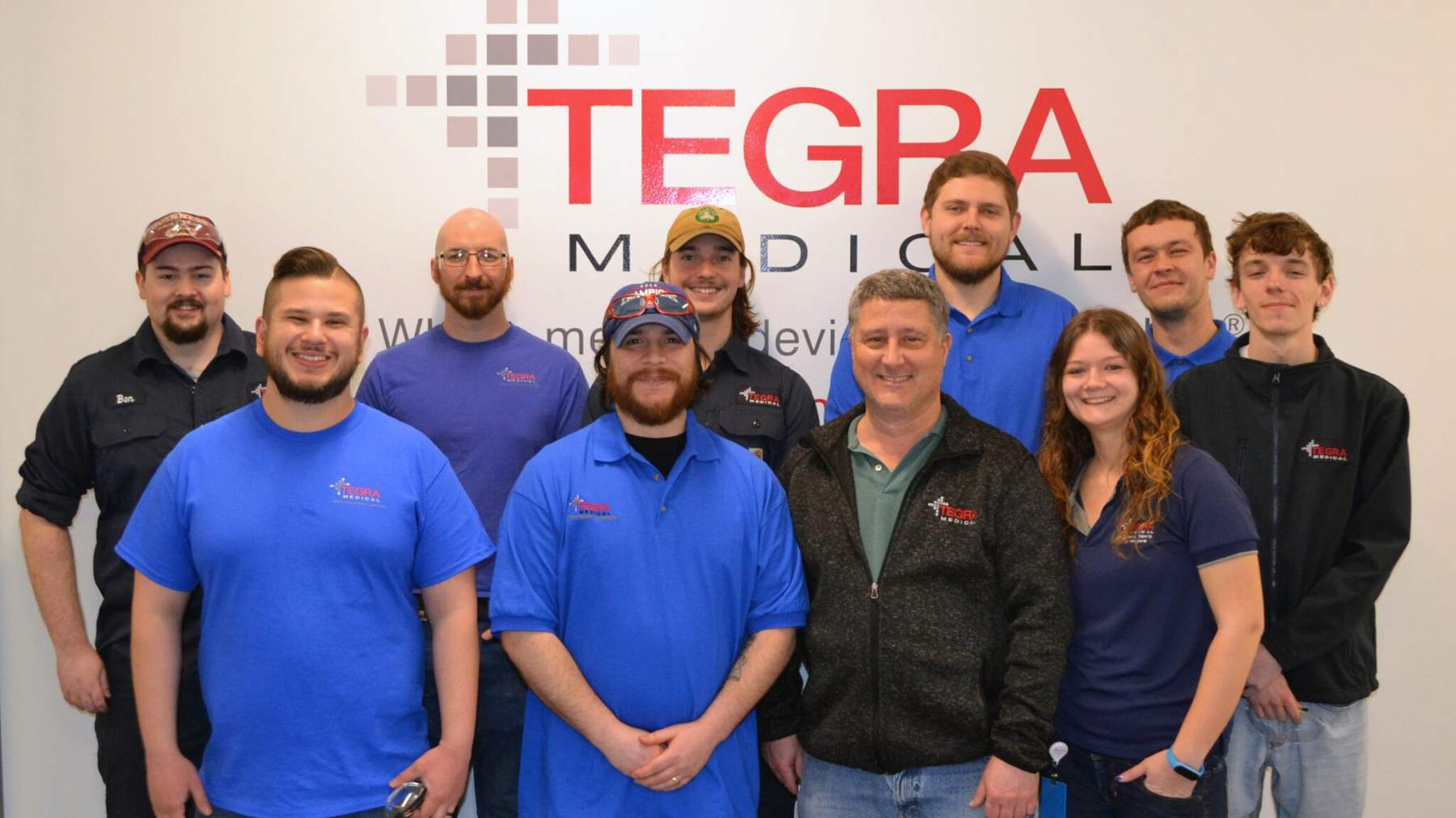 Tegra Medical colleagues posing together beside the company name