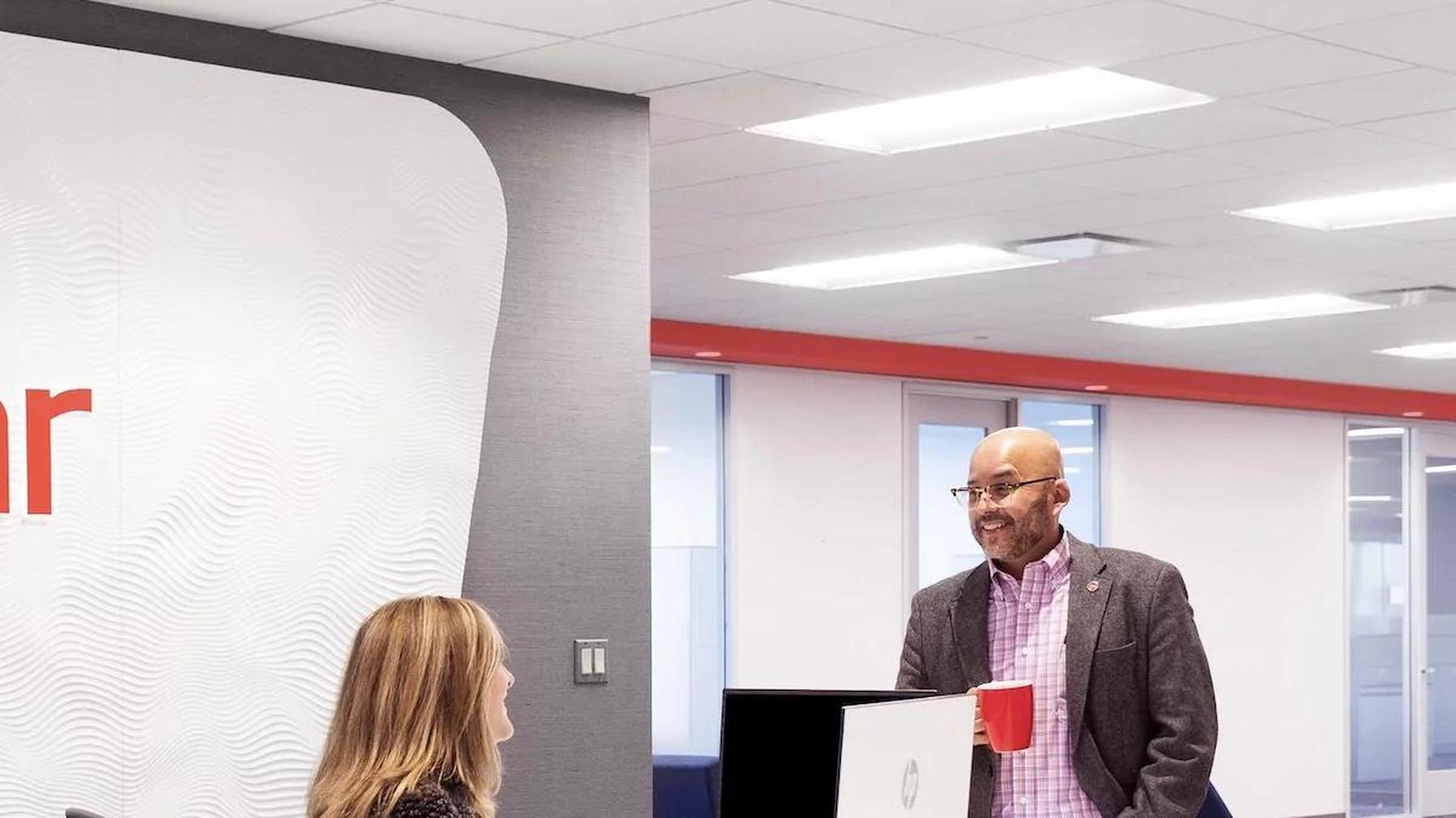 Two Tolmar colleagues talking together at the company’s office reception