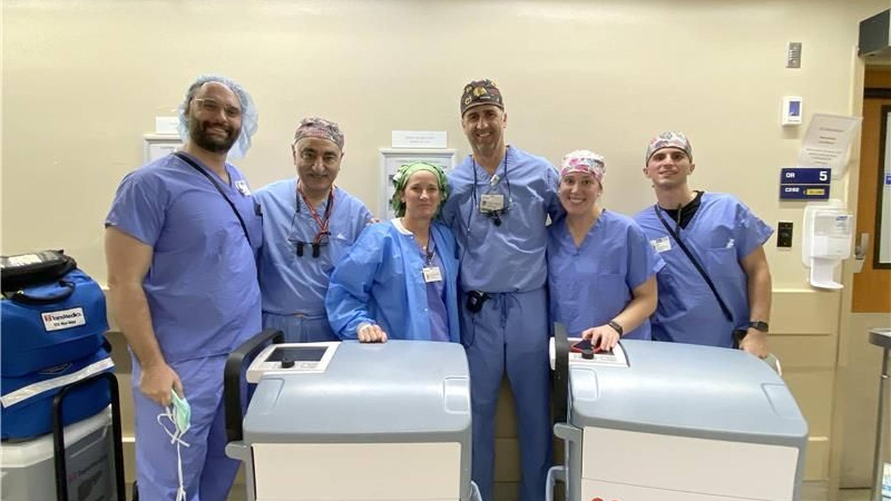 TransMedics clinical colleagues gathered beside two Organ Care Systems