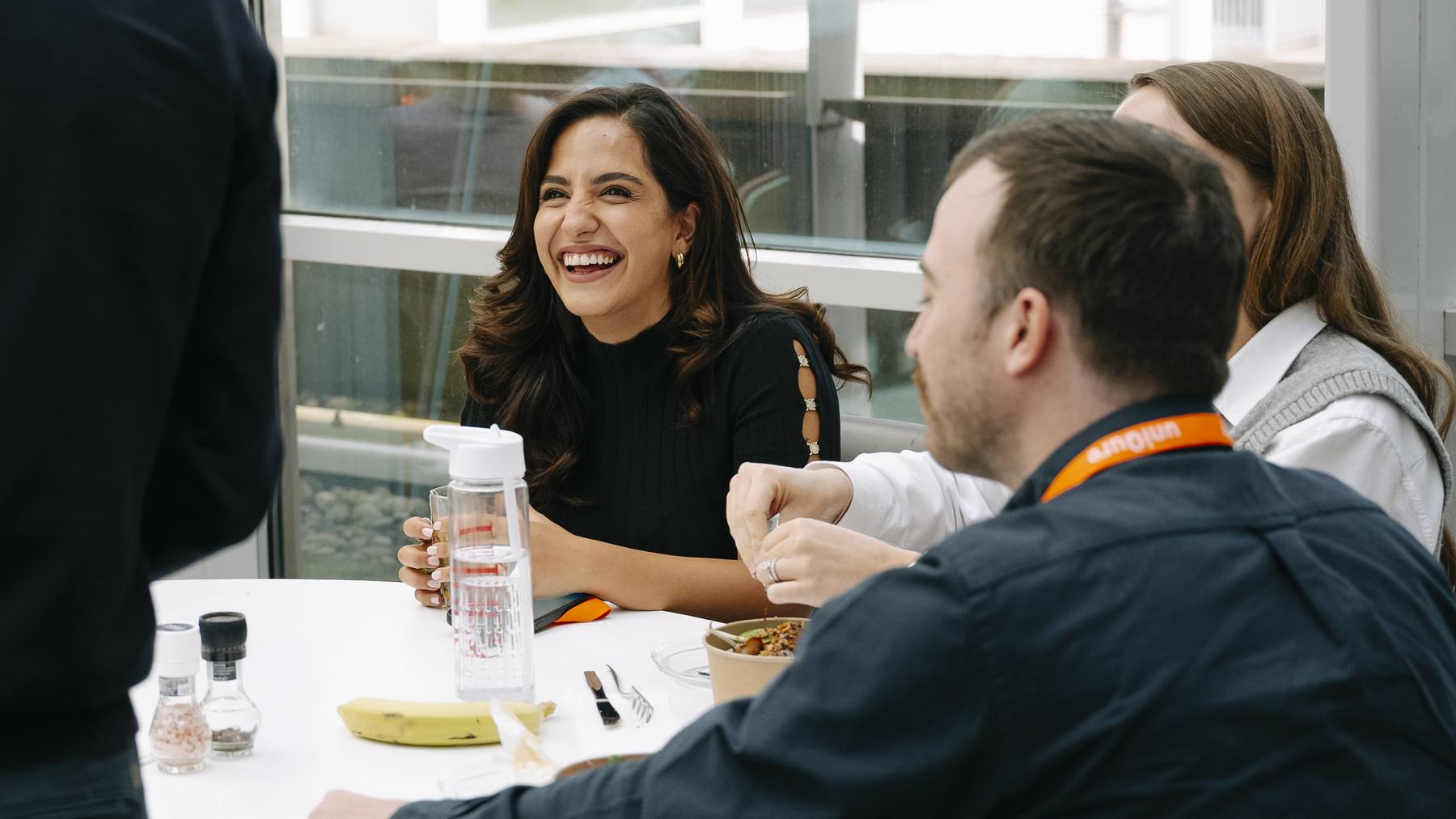 uniQure colleagues smiling and talking around a shared table