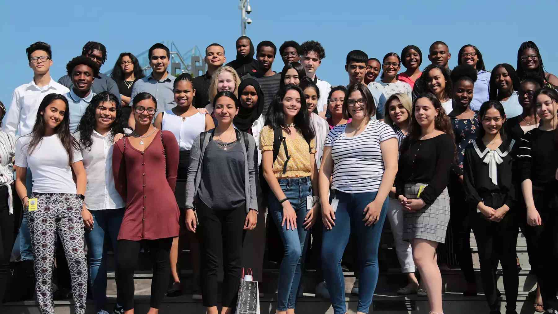 A large group of smiling Vertex interns posed together on an outdoor terrace